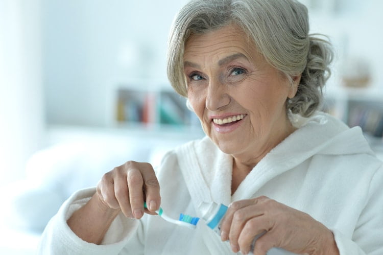 senior woman brushing teeth