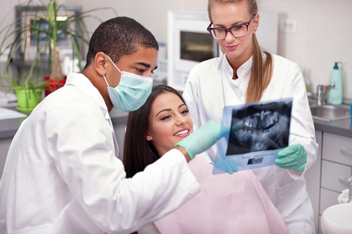 Dentist explaining the details of x-ray picture to his patient