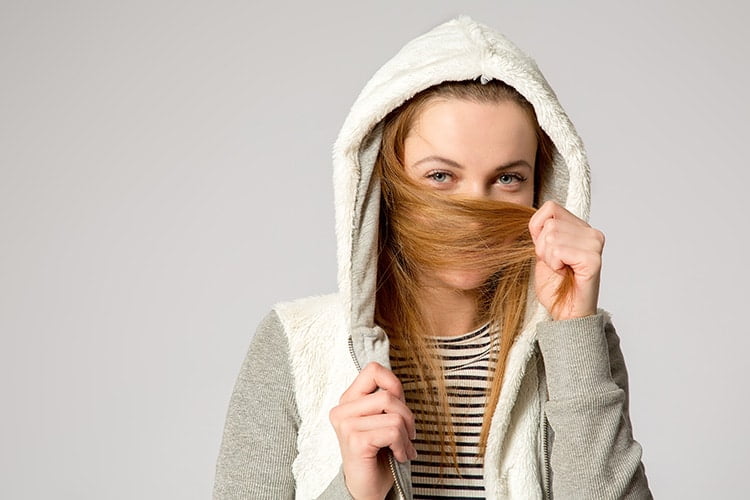 Girl with missing teeth hiding face