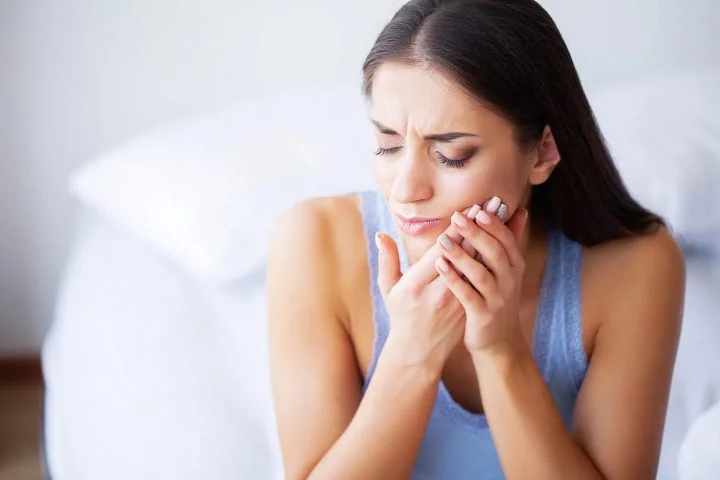 Woman holding sore wisdom teeth