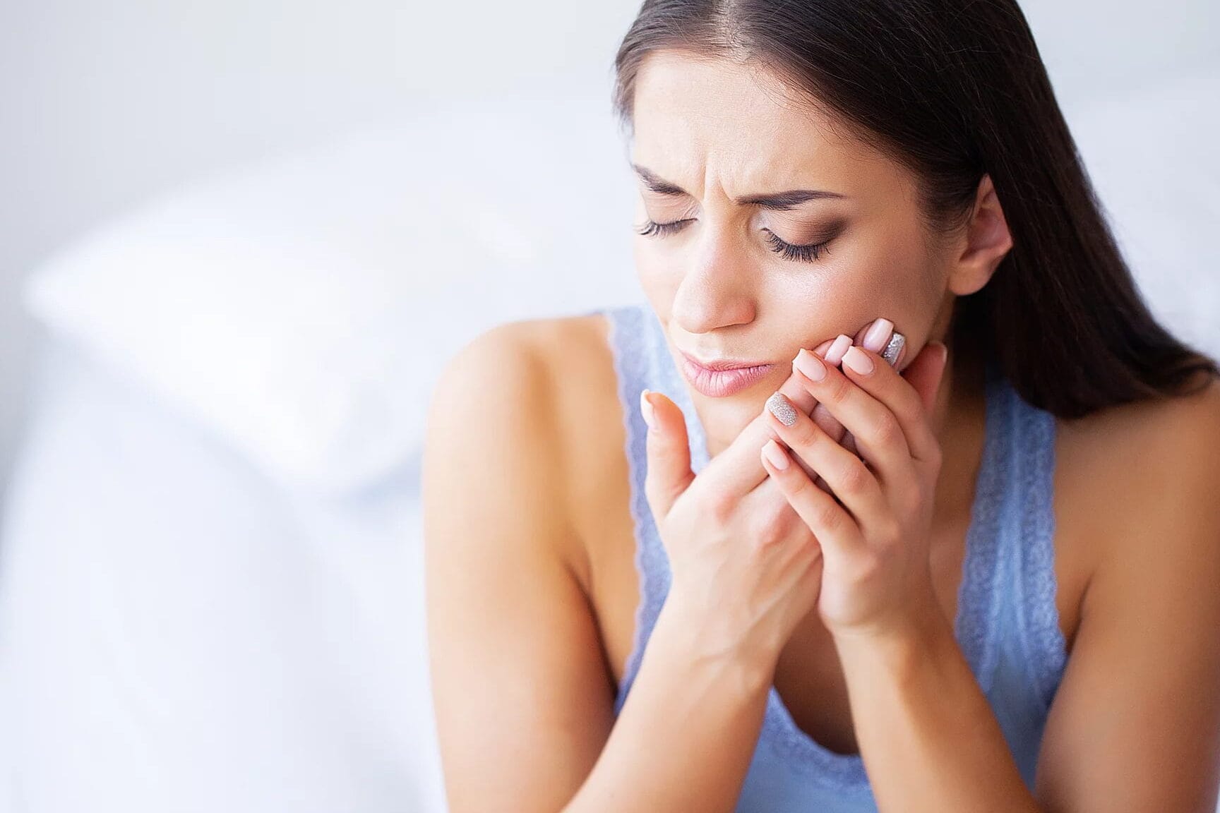 Woman holding sore wisdom teeth